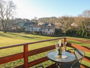 a table with two glasses of wine on a balcony at The Loft in Bradwell