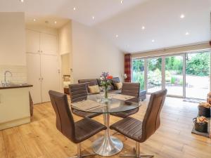 une salle à manger avec une table et des chaises en verre dans l'établissement Hazel Cottage, à Belper