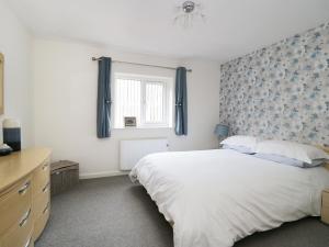 a bedroom with a large bed with a blue patterned wall at The Milking Parlour in York