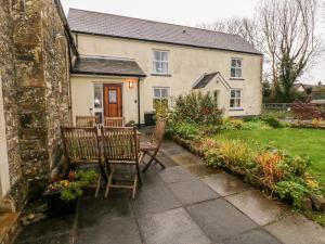 a house with two chairs and a table in the yard at School House in Haverfordwest