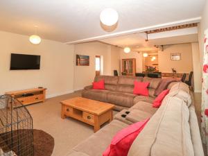 a living room with a couch and a tv at The Old Barn in Swanage