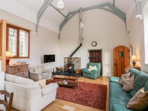 a living room filled with furniture and a fireplace at School House in Haverfordwest