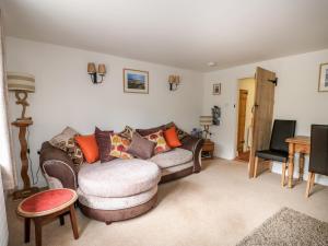 a living room with a couch and a chair at Flint Cottage in Swaffham