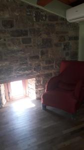 a red couch in a room with a stone wall at Agriturismo La Ginestra in Cercemaggiore