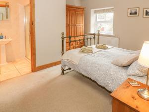 a bedroom with a bed and a bathroom at Bridge House in Hawes