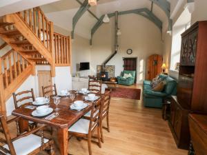 a dining room and living room with a table and chairs at School House in Haverfordwest