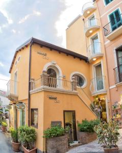 ein gelbes Gebäude mit Balkonen auf einer Straße in der Unterkunft Casa Turrisi in Taormina