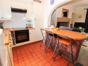 una cocina con mesa y algunas sillas. en Corbett Cottage, en Cheswick