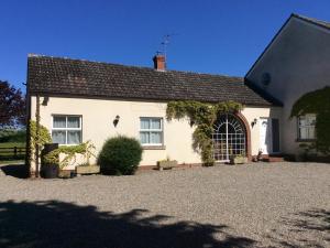 a white house with a driveway in front of it at Rose Villa in Llanymynech