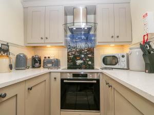 uma cozinha com um fogão e um micro-ondas em Honey Bee Cottage em Scarborough