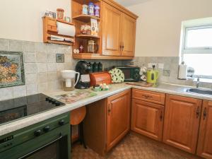 a kitchen with wooden cabinets and a counter top at Sycamore Cottage in Cotterdale