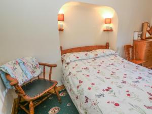 a small bedroom with a bed and a chair at Sycamore Cottage in Cotterdale
