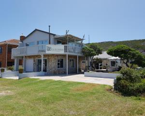a house with a large yard in front of it at Beachcombers in Agulhas