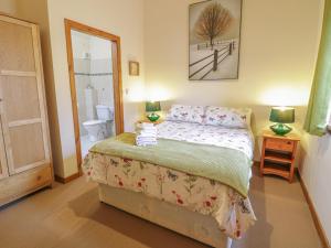 a bedroom with a bed and a bathroom at Lily Cottage in Caernarfon