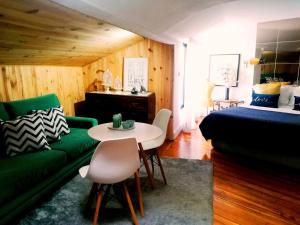 a living room with a green couch and a table at The Gallery Studios in Porto