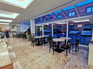 a restaurant with tables and chairs and windows at Hotel Fortune in Cologne