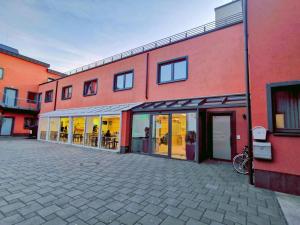 a red building with glass doors and a patio at Hotel Fortune in Cologne