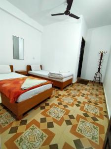 a bedroom with two beds and a floor at Pokhara Youth Hostel in Pokhara