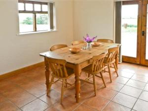 - une table en bois dans une chambre entourée de chaises dans l'établissement Owl Cottage, à Hedon