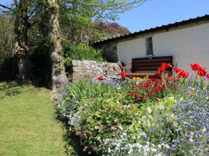 a garden with flowers and a bench in the background at The Cottage in Bideford