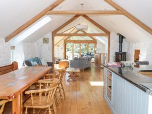 Gwyddelwern的住宿－Tyn Llwyn，一间厨房和带大木桌的客厅