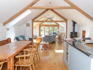 una cucina e un soggiorno con un grande tavolo in legno di Tyn Llwyn a Gwyddelwern
