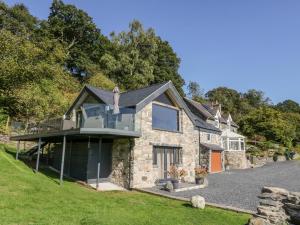 a stone house with a balcony on a hill at Tyn Llwyn in Gwyddelwern