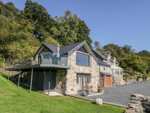una casa in pietra con balcone su una collina di Tyn Llwyn a Gwyddelwern