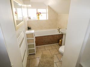 a bathroom with a tub and a sink and a toilet at Hill Farm Cottage in Freshwater