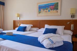 
a hotel room with a bed and two nightstands at Playa Marina Spa Hotel - Luxury in Isla Canela
