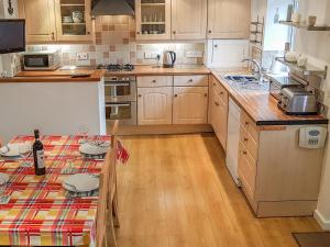 a kitchen with wooden cabinets and a counter top at Rose Cottage in Chard
