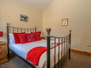 サースクにあるStable Cottageのベッドルーム1室(赤い枕のベッド1台付)