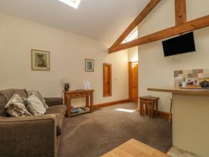 uma sala de estar com um sofá e uma televisão em Stable Cottage em Thirsk