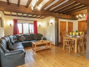 a living room with a leather couch and a table at Ash Lodge in Watchet