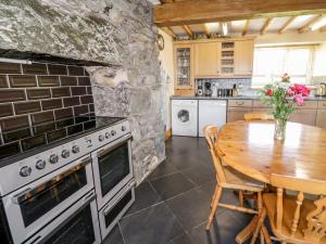 a kitchen with a table and a stone wall at Tyddyn in Dyffryn