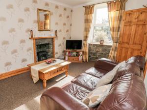 Tyddyn في Dyffryn: غرفة معيشة مع أريكة ومدفأة