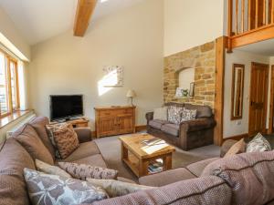 a living room with two couches and a tv at The Granary in Thirsk