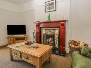 a living room with a fireplace and a tv at Hillside in Broughton in Furness