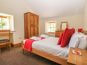 a bedroom with a bed with red pillows on it at The Granary in Thirsk