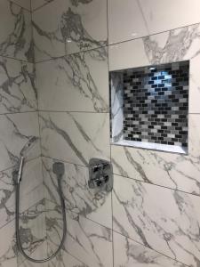 a bathroom with a shower with marble tiles at St Paul's Hotel in London