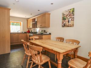 a kitchen with a wooden table and chairs at The Granary in Thirsk