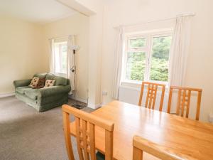 a living room with a table and a couch at Gardener's Cottage in Llandrindod Wells