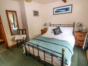 um quarto com uma cama e um espelho em Brook Cottage em Hayfield