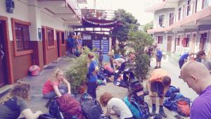un groupe de personnes assises sur le côté d'un bâtiment dans l'établissement Pokhara Youth Hostel, à Pokhara