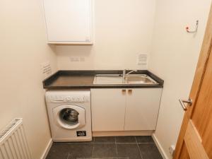 a small kitchen with a sink and a washing machine at The Garden Flat in Buxton