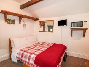 a bedroom with a bed with a red blanket at The Studio in Bradwell