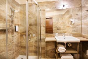a bathroom with a sink and a shower at Golden Tulip Krakow City Center in Krakow