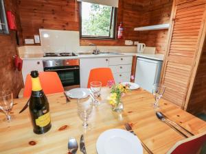 een keuken met een houten tafel en een fles wijn bij Buttermere in Ulverston