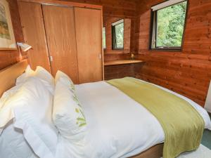 ウルバーストンにあるGrasmereの木造キャビン内のベッド1台が備わるベッドルーム1室を利用します。