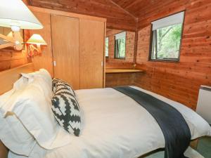 een slaapkamer met een bed in een houten hut bij Buttermere in Ulverston